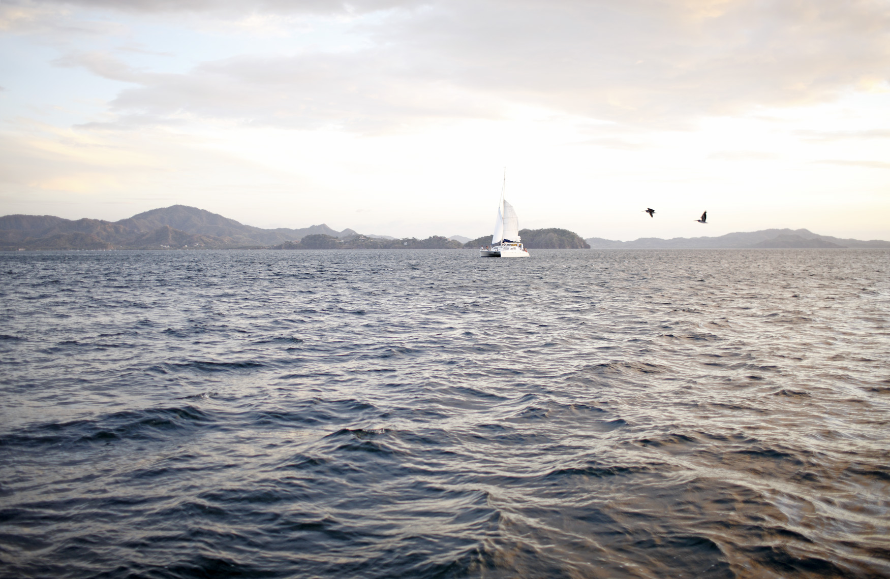 Catamaran sailing in Costa Rica, photographed by Mali Azima.